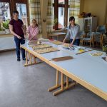 Helfer beim Plätzchenbacken beim Ausrollen von Teig